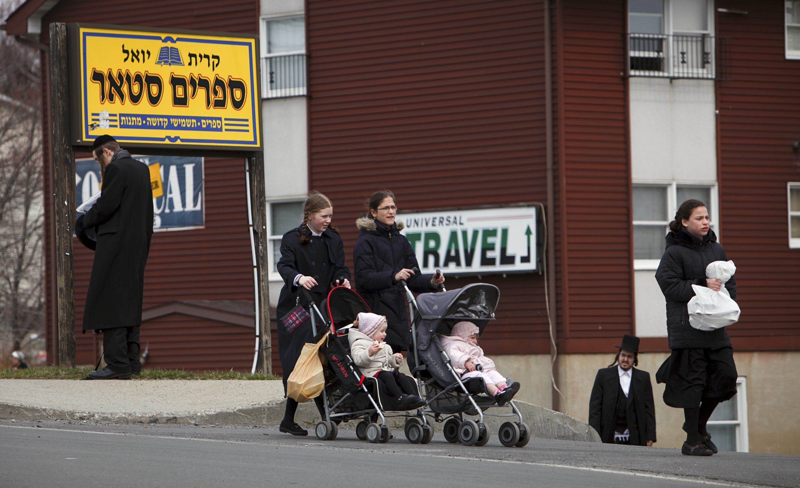 People walk along a main street in the village of Kiryas Joel, N.Y.
